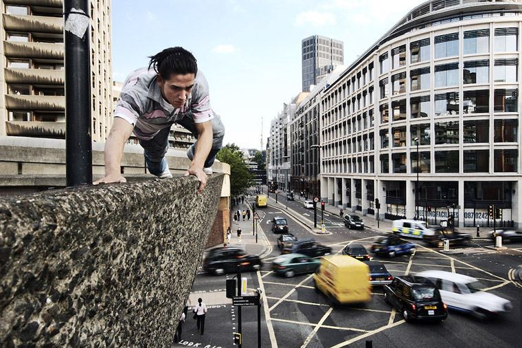 Freerunner Daniel Ilabaca balancing on a wall above a busy street