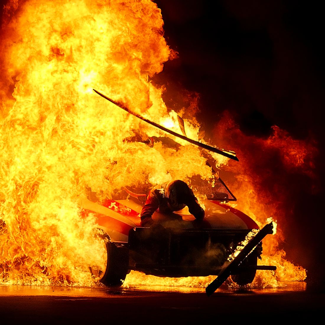 A stunt performer surrounded by planned pyrotechnic flames at a show in Belgium